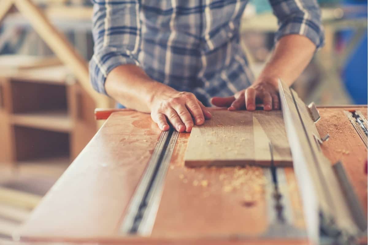 An image of a man ripping a wooden board on a hybrid table saw